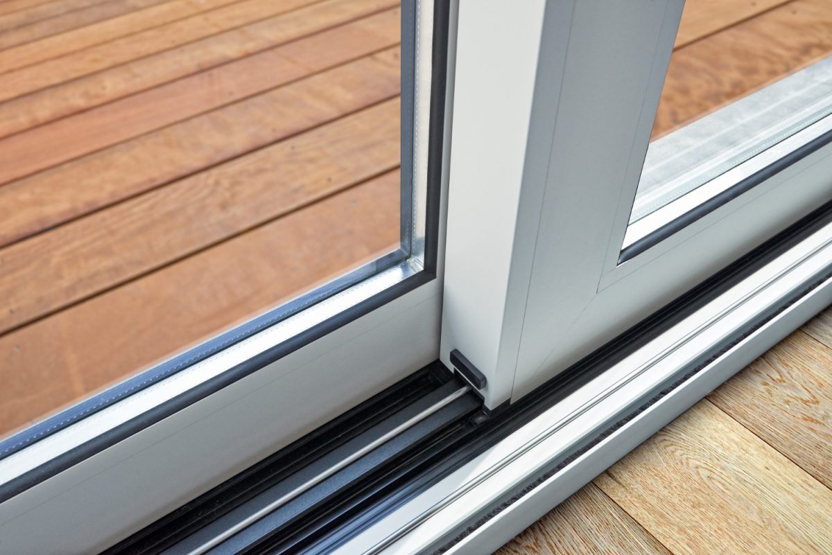 Détail de porte coulissante en verre et rail intégré au sol